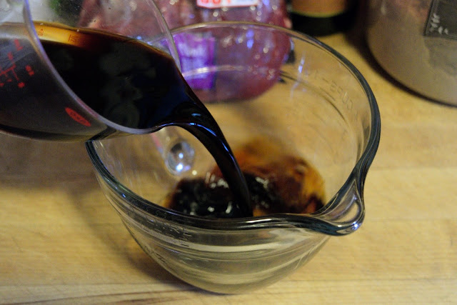 Soy sauce being added to a mixing bowl.