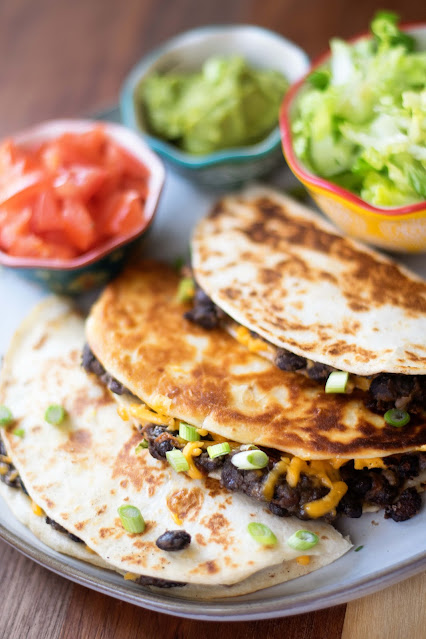 The 3 Ingredient Crispy Black Bean Tacos on a plate with topping around them.