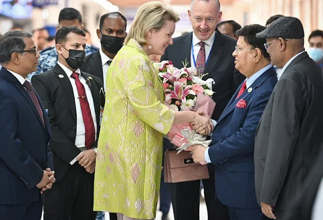 Queen Mathilde wore a yellow floral coat by Emporio Armani, and Nadya midi dress by Anita Dongre. Fakir Apparels garment factory