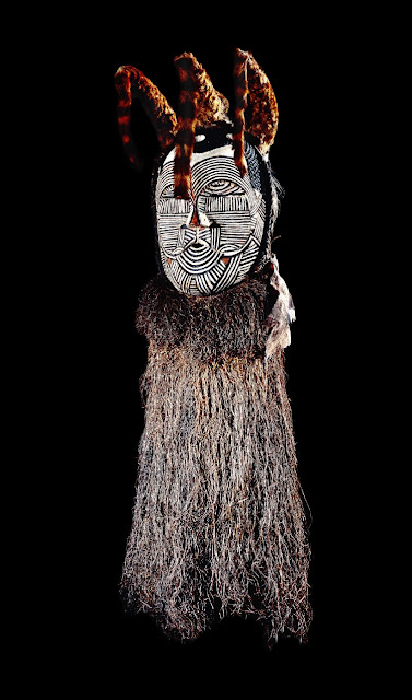 Wooden african mask decorated with fur and fibre fringe 