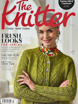 Magazine cover with model wearing a green hand knitted cardigan.