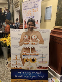 Woman standing behind poster with buns in place of boobs 