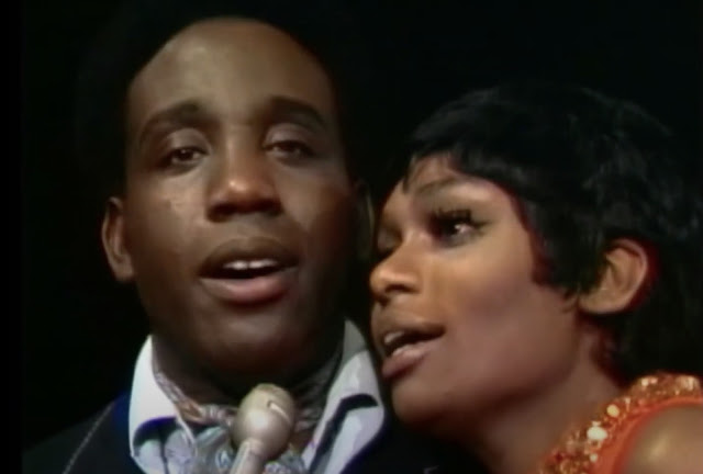 screenshot closeup of Jerry Butler and Vivian Reed singing into a microphone