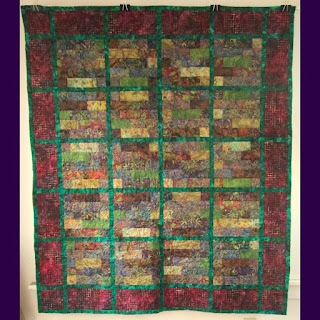 Batik quilt of browns, greens, and purple