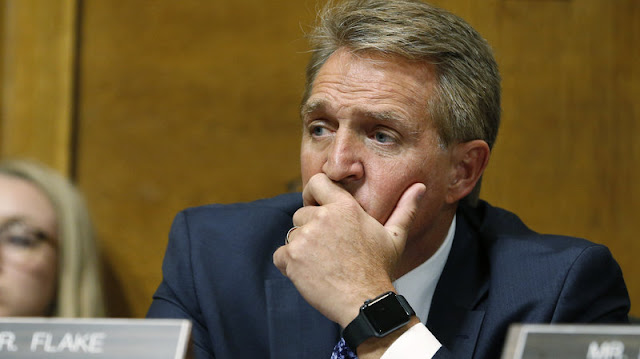 Sen. Jeff Flake, R-Ariz., listens as Christine Blasey Ford testifies before the Senate Judiciary Committee on Thursday.