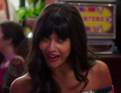 Tahani looking up at Trevor in a conspiratory way with a big grin on her face