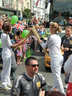 Olympic Flames is passed between two torchbearers.