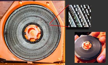 [Image: Close-up shot of a miniature vinyl record, with a detail view of the grooves.]