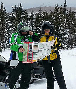 Man and women looking over snowmobile trailmap