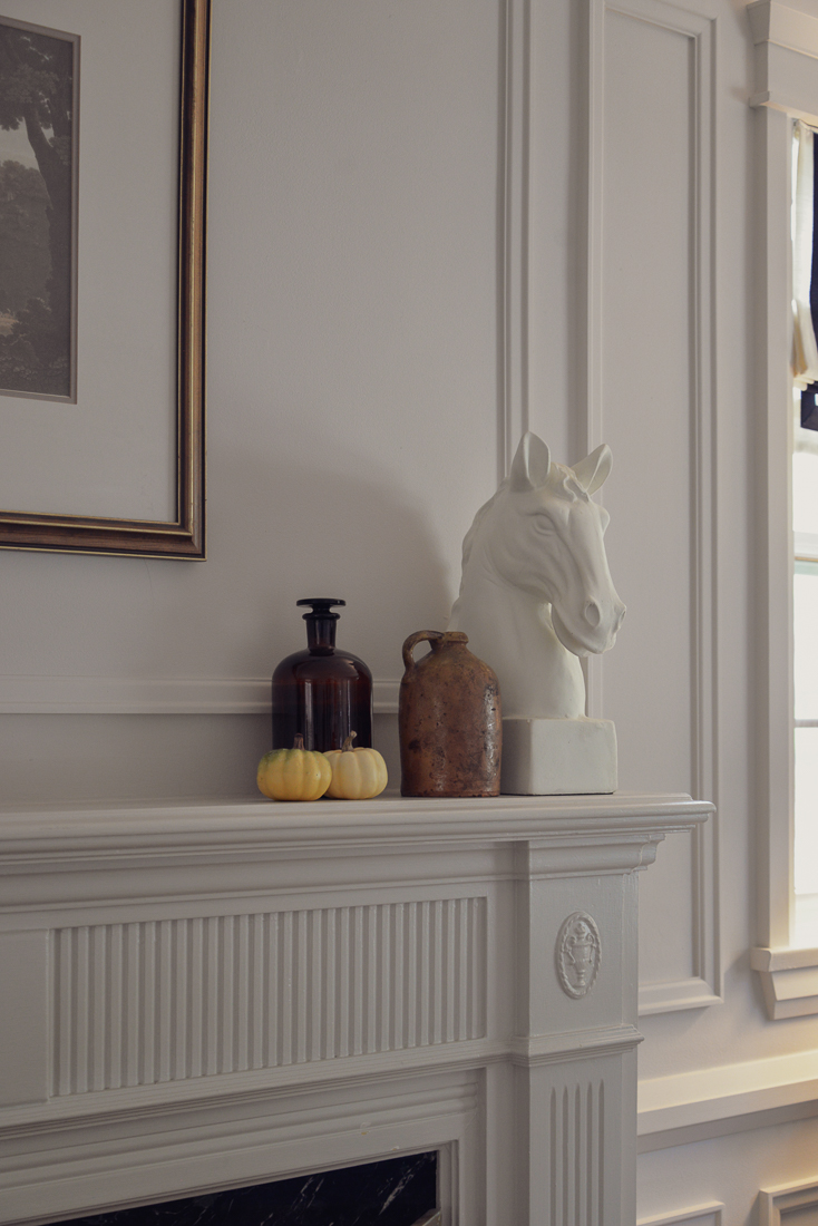 original 1960's fireplace mantel styled with horse bust, glassware, pumpkins, and vintage crocks