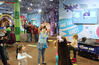 children stand amidst falling bubbles at the Omaha Children's Museum Bubble New Years Eve Party