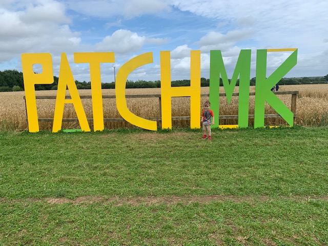 Patch MK signage, with little boy running