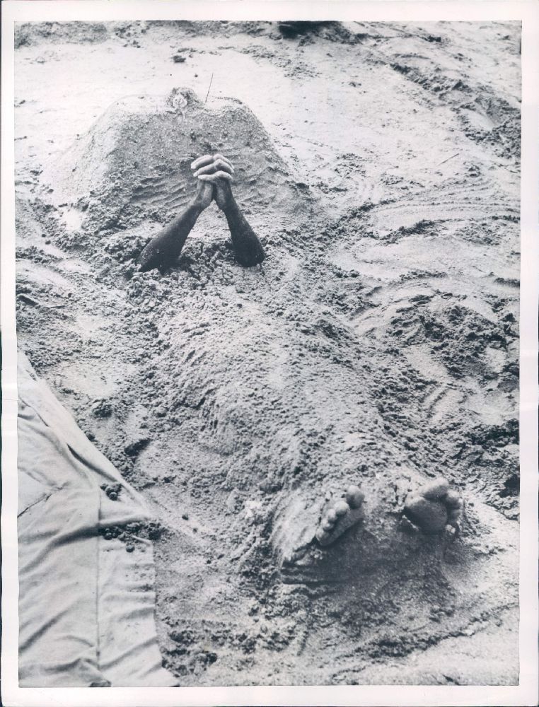 Hindu Man Buried Under Sand Prays to the God of the Rains to Stop the Raining - Bombay (Mumbai) 1953