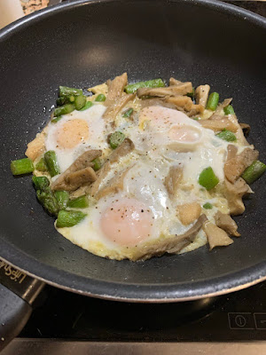 Fotografía de esta receta cocinada en un wok. Lleva setas, espárragos verdes y huevos encima de todo eso, que se dejan cuajar.