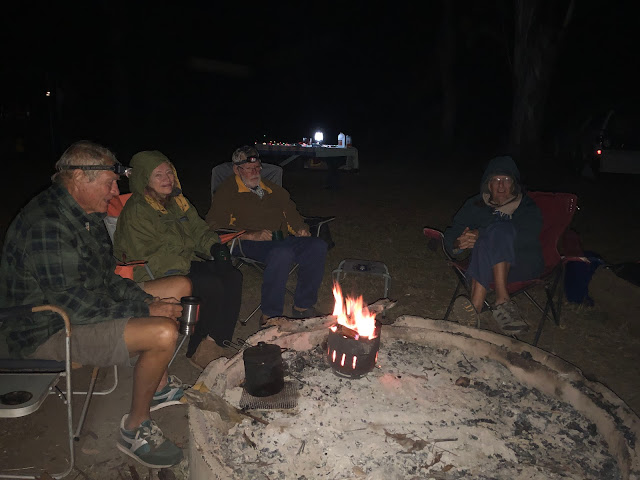 Darryl, Chris, Al and John sitting around the campfire in the dark