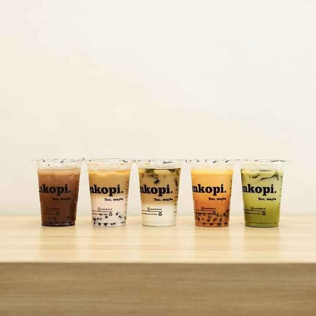 Lima gelas minuman dari Pesenkopi tersusun rapi di atas meja, menampilkan variasi rasa dan warna yang menarik