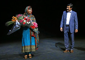 Pakistani schoolgirl Malala Yousafzai, the joint winner of the Nobel Peace Prize, stands with her father Ziauddin after speaking at Birmingham library in Birmingham, central England, October 10, 2014. REUTERS/Darren Staples