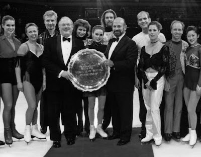 Competitors at the 1996 World Team Championships posing with Dick Button and a corporate sponsor - left to right: Katarina Witt, Jayne Torvill and Christopher Dean (Team Europe), Natalia Bestemianova, Ekaterina Gordeeva and Andrei Bukin (Team Russia), Martin Smith and Michelle McDonald (Team Canada) and Scott Hamilton and Kristi Yamaguchi (Team USA)