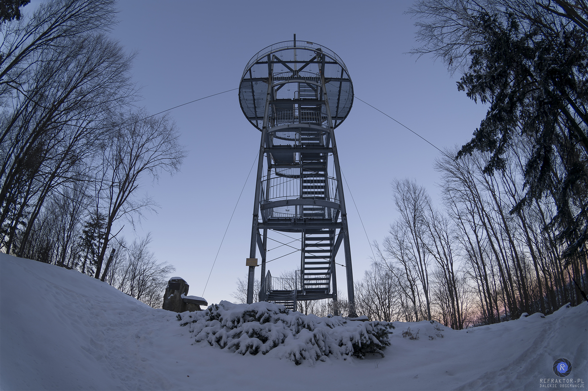 Metalowa wieża na szczycie Jaworzy, stabilizowana stalowymi odciągami. Wieża jest zwieńczona krzyżem.