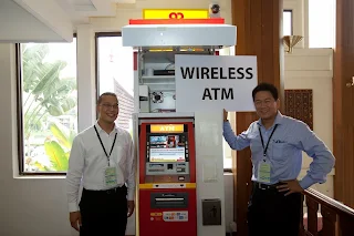 gambar dua orang lelaki dewasa memperkenalkan wireless ATM