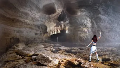 A scene of a dancing girl in the white dress under the sculpture carved cave- sad girl dp