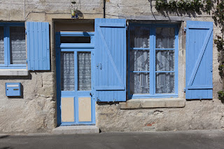 foto de casinha do vilarejo com portas e janelas azuis  