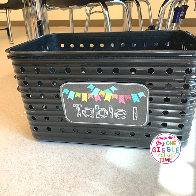 crate on floor next to table to collect student supplies