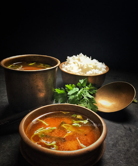 A bowl of Kerala Style Rasam, garnished with fresh coriander leaves, which is one best ozhichu curry to serve during Onam Sadhya.