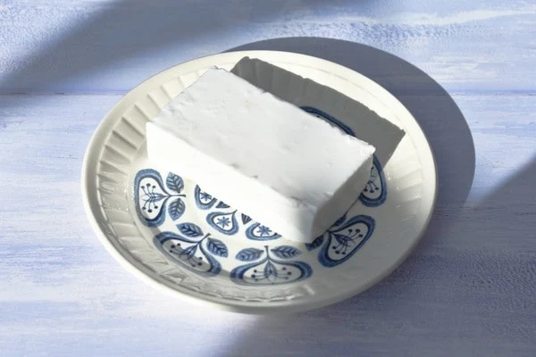 a block of feta cheese on a saucer.