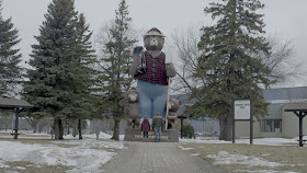 a man and a woman and a smokey the bear statue
