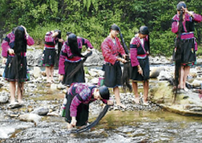SEKUMPULAN wanita Yao Merah membasuh rambut mereka di sungai.