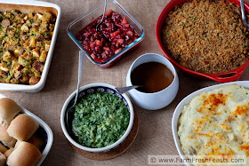 image of a Thanksgiving side dish layout, with stuffing, rolls, creamed spinach, cranberry sauce, green bean casserole and mashed potatoes. Oh, and gravy. I always forget the gravy.