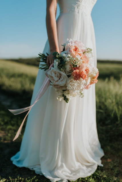 woman standing in field holding a Bridal bouquet