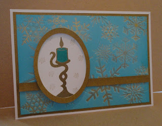 Christmas card in turquoise and gold with candle and snowflake background