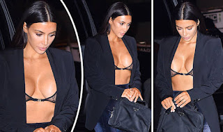 Kim Kardashian wearing a plunge bra under a black coat exposing the most bottom part of her breasts