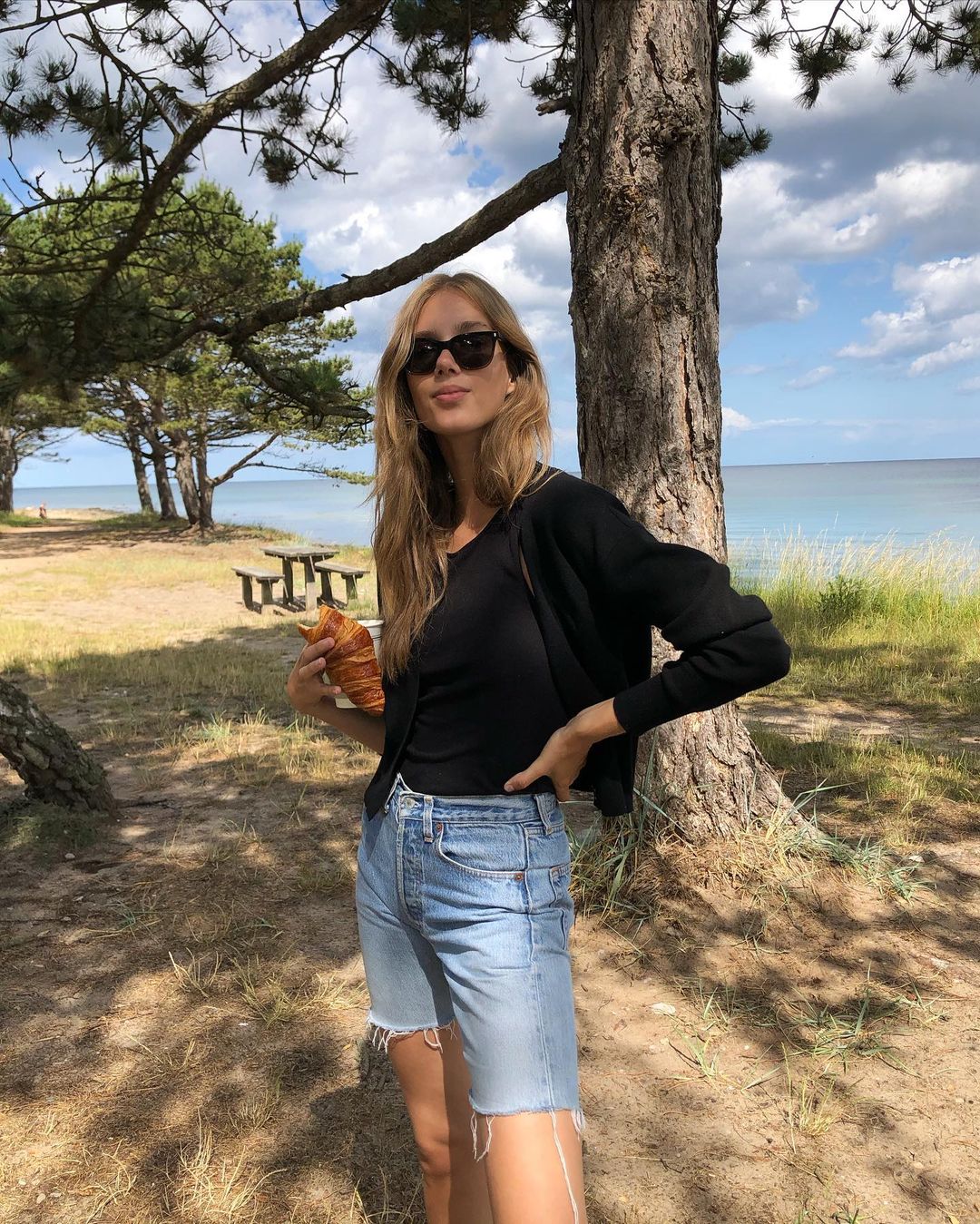 Sacnidnavian Spring Outfit Summer outfit Idea — Cecilie Moosgaard Nielsen in a black tank top, cardigan and long jean shorts