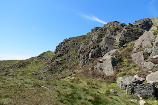 A narrow path leads uphill through grass to the left of the rocky Daear Ddu ridge.