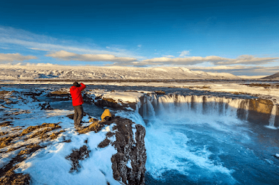 Gullfoss Waterfall cascading into a deep canyon under golden sunlight