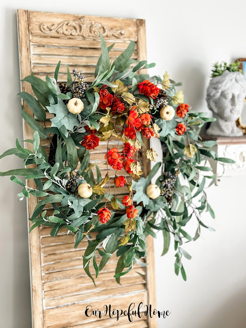 deconstructed fall wreath hanging on vintage shutter