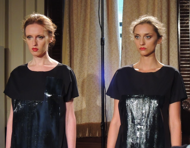 Two models in patent black dresses with chiffon