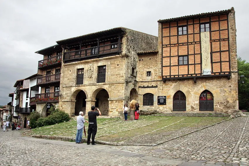 Largo com pessoas a tirarem fotografias em frente a edifícios históricos
