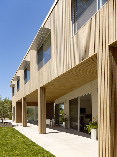 Wooden Pillars and the Wooden Wall near the Grass Yard outside Home