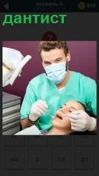 В кресле у дантиста сидит пациентка с открытым ртом, которой доктор проводит санацию