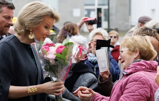 Queen Mathilde wore a forest green printed dress by Dries Van Noten. Tikli Jewelry gold earrings and bracelet