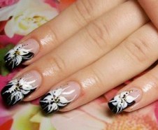 Foto de diseño de uñas con bellas flores de color blanco y negro