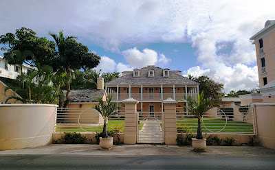 colonial style two storied building with balcony behind gate entrance