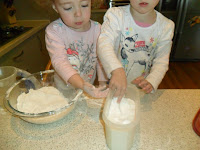 Two children measuring ingredients.