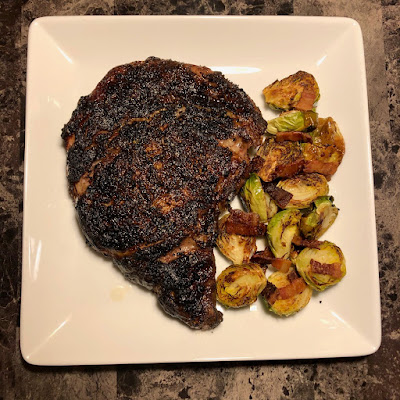 Boneless ribeye grilled Pittsburgh rare with bacon roasted Brussels sprouts