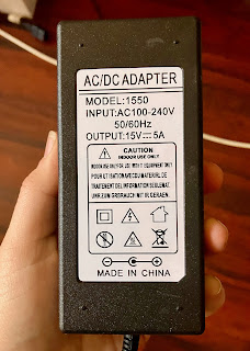 A photo of the sticker on the back of an inverter pack. It reads: "AC/DC ADAPTER. Model: 1550. Input: AC100-240V, 50/60Hz. Output: 15V-5A. Caution: indoor use only, for use with IT equipment only. Made in China”.