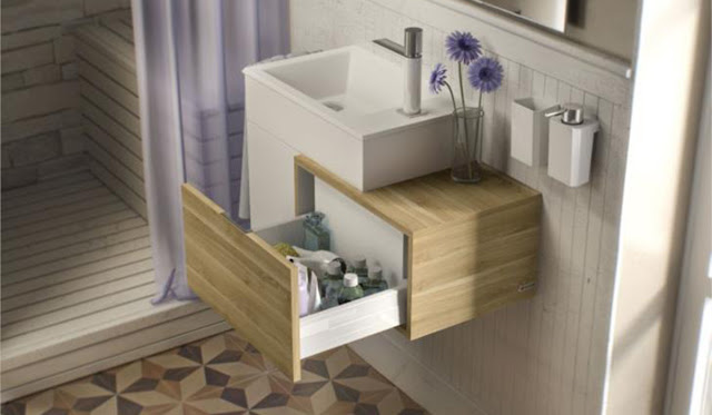 Wood grain single wall mounted vanity in a small bathroom with a patterned tile floor.